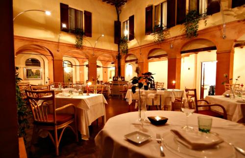 Bagnara di Romagna洛坎达迪巴尼雅拉酒店的餐厅配有桌椅和白色桌布