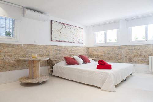 锡切斯Studio Relax by Hello Homes Sitges的一间卧室配有一张红色枕头的床