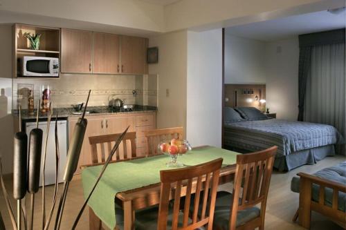 门多萨龚多尔套房公寓酒店的厨房以及带桌子和床的用餐室。
