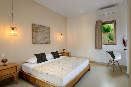 坎古苍谷海滩公寓的卧室配有床、椅子和窗户。