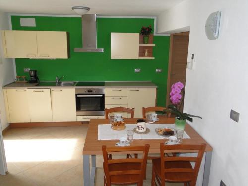 莫斯特纳索契Apartma Jezero的厨房配有桌椅和绿色的墙壁