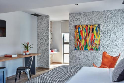 雅典米康海峡18号酒店的卧室配有一张床,墙上挂有绘画作品