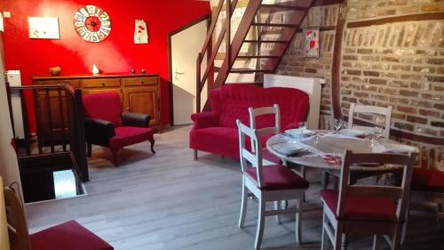 杜柏Le poirier de Warre的一间带桌子和红色椅子的用餐室