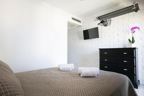 罗萨斯蒙特马尔酒店的一间卧室配有一张床、一个梳妆台和电视。