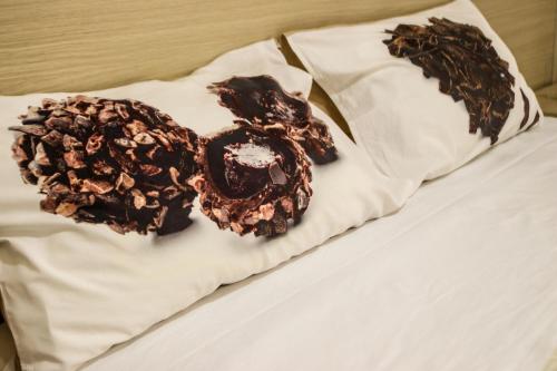 圣塞韦罗Romano B&B的床上有两只巧克力盖的甜甜圈