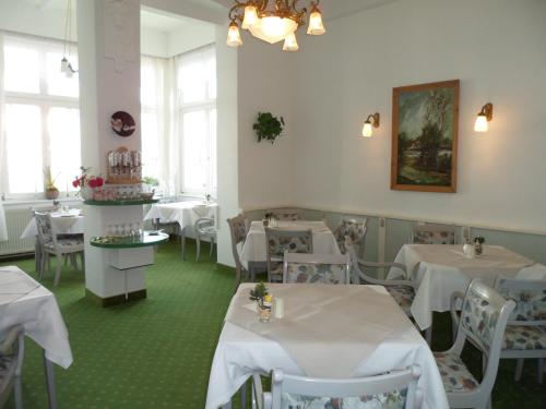 赛巴特班森施伦斯贾尼酒店的餐厅设有白色的桌椅和窗户。