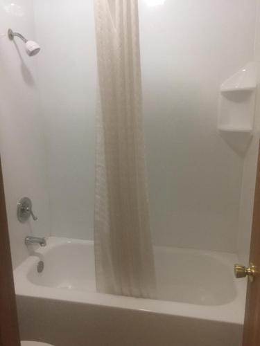 尤里卡尤里卡美国最佳价值套房酒店的浴室配有淋浴帘和浴缸。