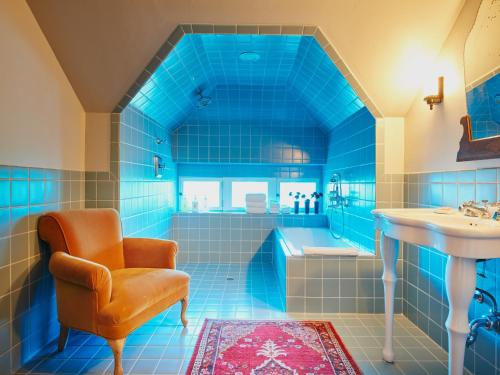 圣安东尼奥哈瓦那酒店的蓝色的浴室设有浴缸、椅子和水槽