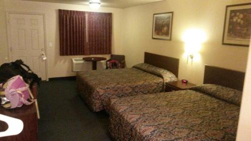 CalienteShady Motel的酒店客房设有两张床和窗户。