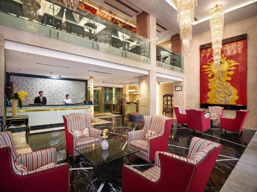 河内河内丝绸之路酒店的大堂设有红色椅子和桌子,酒吧