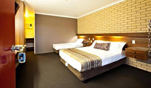 Sarina萨里娜汽车旅馆的酒店客房带两张床和砖墙