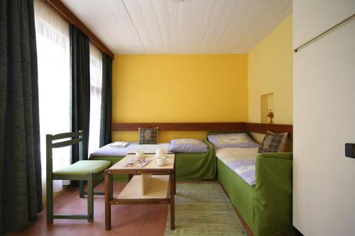 巴拉通雷勒Hotel Melis的酒店客房带两张床、一张桌子和一张桌子。