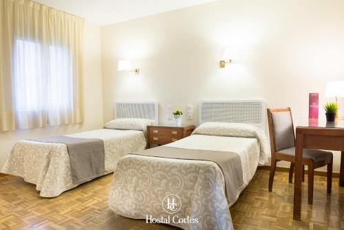 昆卡科尔特斯旅馆的客房设有两张床、一张桌子和一张书桌。