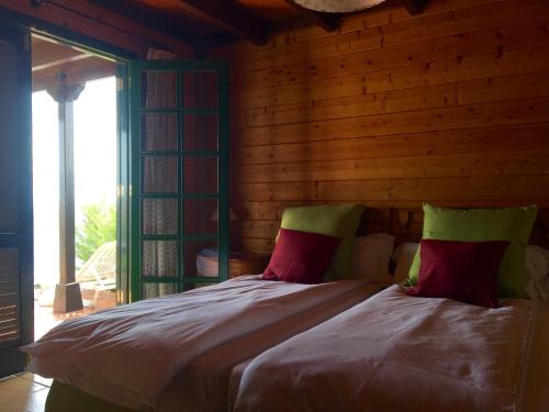 圣地亚哥海滩Apartamentos Santa Ana - Adults Only的一间卧室配有红色和绿色枕头的床