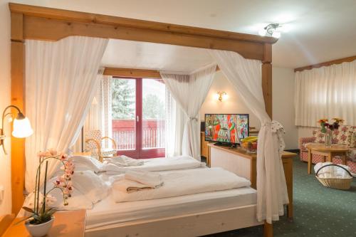 坎波图雷斯黑尔维格酒店的一间卧室配有一张天蓬床和窗户