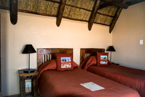 Twee RivierenXaus Lodge的配有木天花板的客房设有两张床。