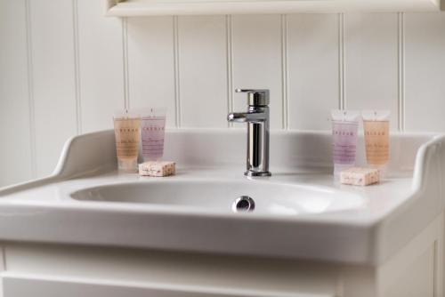 斯佩河畔格兰敦克瑞拉克莱格林恩酒店的浴室水槽,配有2个杯子和水龙头