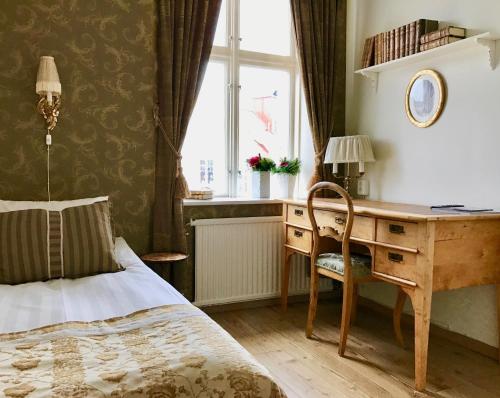 乌德瓦拉Hotell Viking的一间卧室配有书桌、床和窗户。