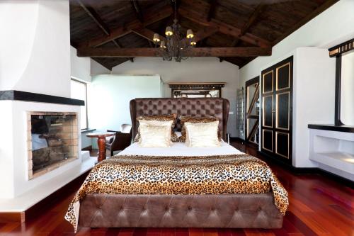 亚伊萨卡萨德希拉里奥酒店的一间卧室配有一张大床和一张带猎豹纹床单