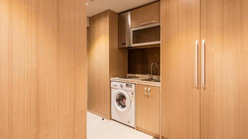 首尔First Stay Hotel的厨房配有洗衣机和洗衣机。