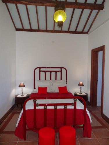 富尔纳斯Casa do Rei的一间卧室配有红色的床和两张红色椅子