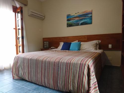 伊利亚贝拉Galápagos ApartHotel的一间卧室配有一张带条纹毯子的大床