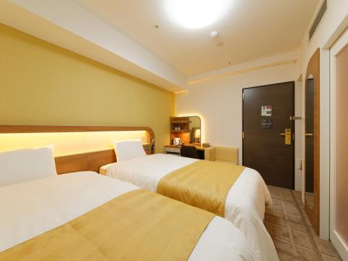 神户神户灿路都大饭店别馆的一间酒店客房,设有两张床和一扇门