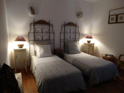 Saint-Vincent-de-Paul伯格罗斯酒店的一间卧室设有两张床和两张台灯。