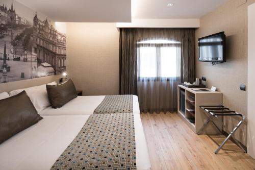 巴塞罗那加泰罗尼亚博恩酒店的酒店客房,配有床和电视
