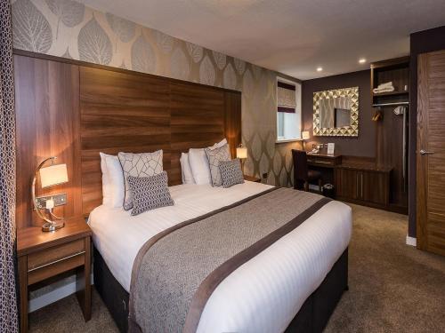大克里夫顿The Melbreak Hotel的酒店客房设有一张大床和一张书桌。