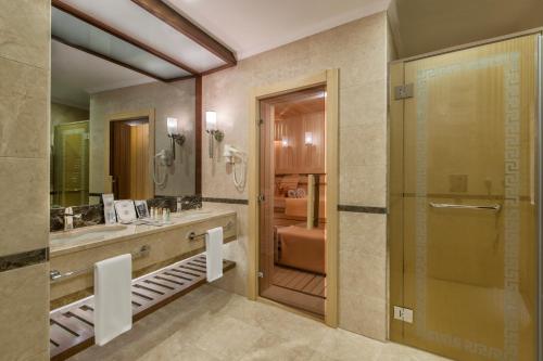 阿菲永Akrones Thermal Spa Convention的带淋浴、盥洗盆和镜子的浴室
