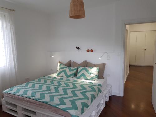蒂瓦特Bright Central Apartman的一间卧室配有一张带绿色和白色棉被的床