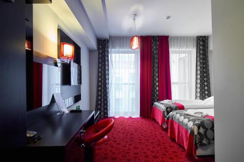 热舒夫吉莫维特酒店的酒店客房配有两张床和一张书桌