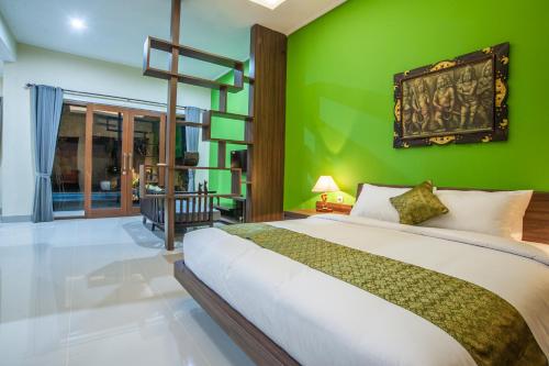 沙努尔阿斯塔纳玛德别墅的一间拥有绿色墙壁和一张大床的卧室