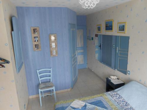 Saint-Laurent-de-la-PréeLa Roche bleue的卧室拥有蓝色的墙壁,配有椅子和床