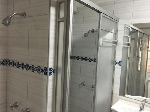 利马Kelebek Hostel的带淋浴、盥洗盆和镜子的浴室