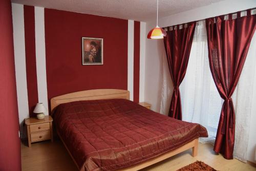 利夫诺Apartment Mario的一间卧室配有一张红色棉被的床