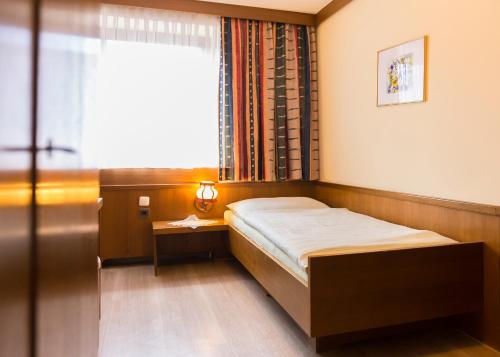 赫尔兴格斯曼德福宾馆的一间小卧室,配有床和窗户
