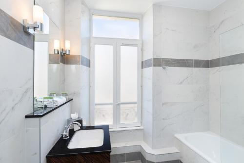 尼斯快乐文化杰伊酒店的白色的浴室设有水槽和窗户。