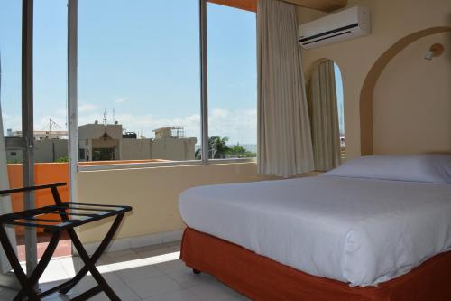卡门城Hotel del Parque的窗户房间里的床和椅子