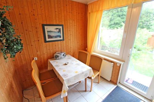 瓦伦Ferienwohnung Waren SEE 8211的一间带桌椅和窗户的用餐室