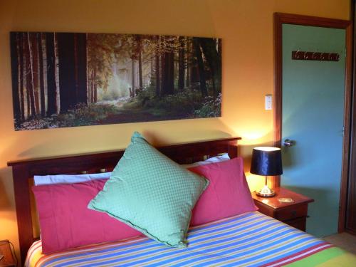 Island Beach港口小岛海滩度假屋的一间卧室配有带粉色和绿色枕头的床