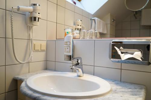 巴德艾森卡珀尔Pension Besser的浴室设有白色水槽和镜子