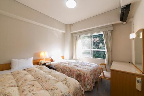 本宫山水馆川汤松屋酒店的酒店客房设有两张床和窗户。