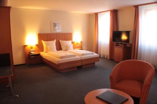 贡岑豪森鲍尔沃尔夫酒店的一间酒店客房,配有一张床和一台电视