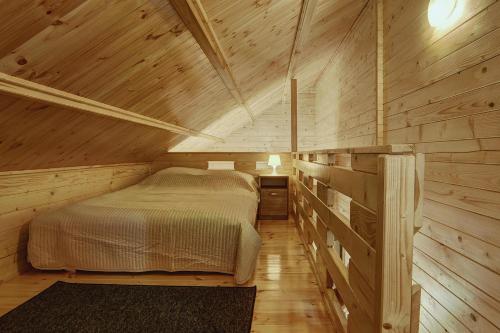尤斯托尼莫斯基Biała Wioska 1的小木屋内一间卧室,配有一张床
