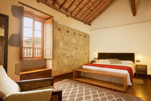 大加那利岛拉斯帕尔马斯艾尔蒙达隆乡村酒店的一间卧室设有一张床和石墙