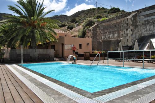 大加那利岛拉斯帕尔马斯艾尔蒙达隆乡村酒店的一座游泳池,旁边是一座棕榈树