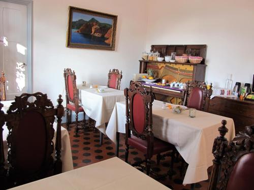 戛纳美丽海岸别墅旅馆的餐厅配有2张桌子和椅子以及白色的桌布