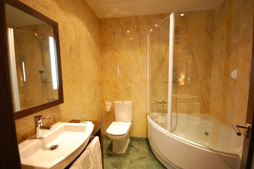 多斯托雷斯Hotel Los Usías的一间带水槽、浴缸和卫生间的浴室